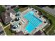 Overhead view of community pool with lap lanes, umbrella-shaded seating, and mature landscaping around the perimeter at 104 Crossway Ln, Holly Springs, NC 27540