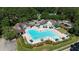 Aerial view of the community pool, featuring plenty of seating and shady umbrellas, surrounded by lush green trees at 104 Crossway Ln, Holly Springs, NC 27540