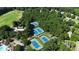 Aerial view of community tennis courts surrounded by lush greenery, near pool and parking at 104 Crossway Ln, Holly Springs, NC 27540