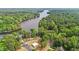 An aerial view of a lakeside property surrounded by dense woodlands and pristine water at 104 Pontiac Cv, Louisburg, NC 27549