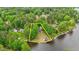Aerial view highlighting a waterfront property with lush trees and a private boat dock at 104 Pontiac Cv, Louisburg, NC 27549