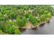 An aerial view of a waterfront property with lush trees and a private boat dock at 104 Pontiac Cv, Louisburg, NC 27549