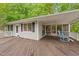Spacious back deck featuring a covered porch, rocking chairs, and access to the outdoors at 104 Pontiac Cv, Louisburg, NC 27549