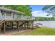 Back of lake house featuring a large deck overlooking the lake and a boat house at 104 Pontiac Cv, Louisburg, NC 27549