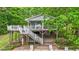 Lake house featuring a deck, stairs, patio, and lush landscaping at 104 Pontiac Cv, Louisburg, NC 27549