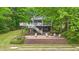 Inviting lake house with elevated deck, stairs and tiered brick patio with lounge seating at 104 Pontiac Cv, Louisburg, NC 27549