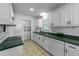 Well-lit kitchen with green countertops, white cabinets, and matching appliances at 104 Pontiac Cv, Louisburg, NC 27549