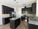 Stylish kitchen with stainless steel appliances, granite countertops, and dark cabinets at 105 Blue Bay Ln, Cameron, NC 28326
