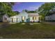 Charming home with white brick, turquoise door, wood shutters, and a manicured lawn at dusk at 105 N 11Th St, Erwin, NC 28339