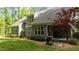 Scenic backyard featuring a grill, mature trees, and a covered patio at 110 Pebble Creek Dr, Franklinton, NC 27525