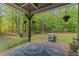 Outdoor patio with a seating area, grill, and a view of the expansive backyard featuring lush greenery and mature trees at 110 Pebble Creek Dr, Franklinton, NC 27525