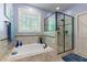 This primary bathroom includes a soaking tub and a separate glass-enclosed shower, and a window for natural light at 110 Pebble Creek Dr, Franklinton, NC 27525