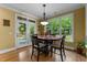 Bright breakfast nook with hardwood floors, a table for four, and a view of the backyard through large windows and a door at 110 Pebble Creek Dr, Franklinton, NC 27525