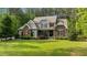 Charming two-story home featuring stone accents, gray siding, manicured lawn, and lush landscaping surrounded by mature trees at 110 Pebble Creek Dr, Franklinton, NC 27525