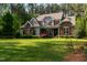 Charming home with a stone and siding exterior, well-manicured lawn, and lush landscaping at 110 Pebble Creek Dr, Franklinton, NC 27525