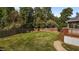 Lush backyard offers a private retreat with mature trees and a wooden fence at 1114 Balmoral Dr, Cary, NC 27511