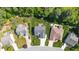 An aerial view showcasing a well-maintained backyard featuring a patio, firepit, shed, and lush landscaping at 114 Bell Tower Ct, Elon, NC 27244