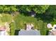 Aerial view showcasing well-maintained backyard featuring a patio, firepit, shed, and lush landscaping at 114 Bell Tower Ct, Elon, NC 27244