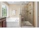 Bright bathroom with a soaking tub, glass-enclosed shower, and natural light at 114 Bell Tower Ct, Elon, NC 27244