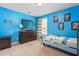 Bright blue bedroom with dresser, carpeting, and whimsical decor at 114 Bell Tower Ct, Elon, NC 27244
