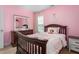 Charming pink bedroom features a full bed, wood floors and window view at 114 Bell Tower Ct, Elon, NC 27244