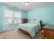 Bedroom with light blue walls, wood furniture, and large sunny window at 114 Bell Tower Ct, Elon, NC 27244