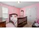 Charming pink bedroom features a crib, wood floors and window view at 114 Bell Tower Ct, Elon, NC 27244