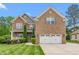 Beautiful brick two-story home with an attached two-car garage and manicured lawn at 114 Bell Tower Ct, Elon, NC 27244