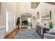 Spacious foyer featuring hardwood floors, staircase, and view into piano room at 114 Bell Tower Ct, Elon, NC 27244