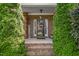 Inviting front porch with brick columns, a 'Welcome' sign, and lush green shrubbery at 114 Bell Tower Ct, Elon, NC 27244