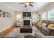 Cozy living room featuring a fireplace, large windows, and a comfortable seating area at 114 Bell Tower Ct, Elon, NC 27244