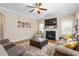 Bright living room with fireplace, large windows, plush sofas, and a ceiling fan at 114 Bell Tower Ct, Elon, NC 27244