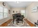 Elegant piano room with a grand piano, hardwood floors, and natural light at 114 Bell Tower Ct, Elon, NC 27244