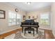 Cozy piano room with natural light and hardwood floors, featuring a grand piano at 114 Bell Tower Ct, Elon, NC 27244