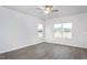 Spacious bedroom with luxury vinyl flooring, a ceiling fan, and bright natural light from two windows at 11412 International Dr, Middlesex, NC 27557