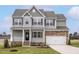 Charming two-story home with gray siding, a stone accent wall, and a well-manicured lawn at 11412 International Dr, Middlesex, NC 27557