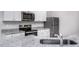 Modern kitchen with white cabinets, granite countertops, stainless steel appliances, and a stylish faucet at 11412 International Dr, Middlesex, NC 27557