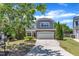 Inviting two-story home with lush green lawn and mature trees, creating a serene suburban setting at 120 Cobblebrook Ct, Holly Springs, NC 27540