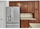 A kitchen with stainless steel refrigerator, warm wood cabinetry, and neutral countertops for a classic design at 120 Cobblebrook Ct, Holly Springs, NC 27540