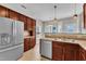 Spacious kitchen featuring stainless steel appliances, warm wood cabinets, and a sunlit dining area with large windows at 120 Cobblebrook Ct, Holly Springs, NC 27540