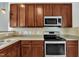 A functional kitchen showcasing ample warm cabinetry, stainless steel appliances, and neutral countertops and backsplash at 120 Cobblebrook Ct, Holly Springs, NC 27540