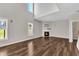 Spacious living room featuring beautiful hardwood floors, a fireplace, and large windows, perfect for relaxation and entertainment at 120 Cobblebrook Ct, Holly Springs, NC 27540