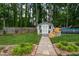 Backyard view with an above ground pool, shed, brick landscaping, stone walkway and tall trees at 1213 Indian Trail Dr, Raleigh, NC 27609