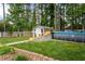 Backyard view with an above ground pool, shed, brick landscaping and tall trees surrounding the property at 1213 Indian Trail Dr, Raleigh, NC 27609