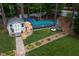 Aerial view of backyard with a shed, pool, outdoor seating, and verdant landscaping at 1213 Indian Trail Dr, Raleigh, NC 27609