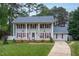 Charming two-story home with mature trees, lush lawn, and inviting front porch for a warm, welcoming feel at 1213 Indian Trail Dr, Raleigh, NC 27609