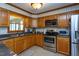 Classic kitchen featuring oak cabinets, stainless steel appliances, and solid surface countertops at 1213 Indian Trail Dr, Raleigh, NC 27609