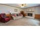 Comfortable living room with a fireplace, neutral-toned carpet, and traditional wood paneling at 1213 Indian Trail Dr, Raleigh, NC 27609