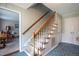 Carpeted staircase with wooden banister and blue tiled foyer at 1213 Indian Trail Dr, Raleigh, NC 27609