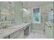 Bright bathroom featuring double vanity, marble countertops, and glass-enclosed shower at 127 Post Oak Rd, Chapel Hill, NC 27516